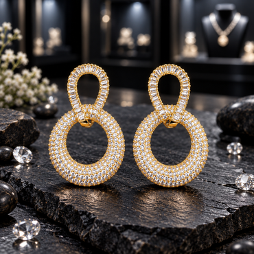 Pair of gold-tone earrings with clear baguette-shaped accents around elongated upper loops and broad round drops covered in small clear-looking accents.