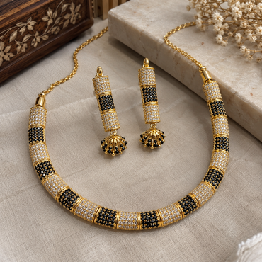 Gold-tone necklace and drop earrings with alternating black and clear pavé-style sections and fan-shaped earring drops.