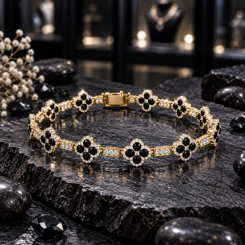 Gold-tone bracelet with black four-petal clover motifs, clear halo borders, rectangular clear-accent links and a rectangular back closure section, arranged on dark slate.