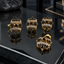 Gold-tone matching earrings, ring and locket with black floral clusters, round centres and two curved rows of clear accents.