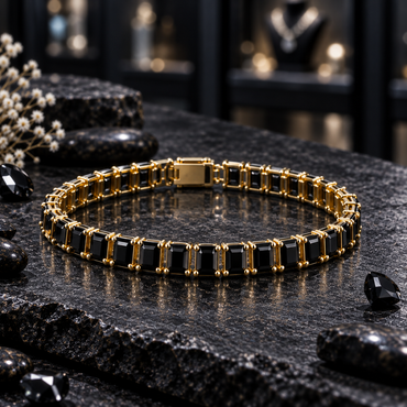 Gold-tone linked bracelet with faceted black rectangular accents, visible prong details and a rectangular back closure section, arranged in an oval on dark slate.