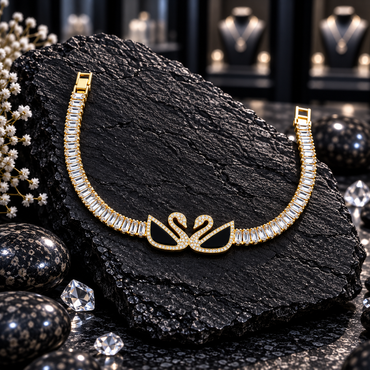 Gold-tone bracelet with two facing black-panel swans, clear-accent necks and borders, and rows of clear rectangular accents.