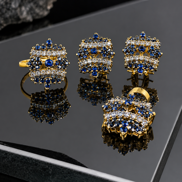 Gold-tone matching earrings, ring and locket with blue floral clusters, round centres and two curved rows of clear accents.