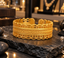 Gold-tone wide open cuff bracelet with an interwoven braided centre, rope-like borders and scalloped openwork edges with bead-like details.