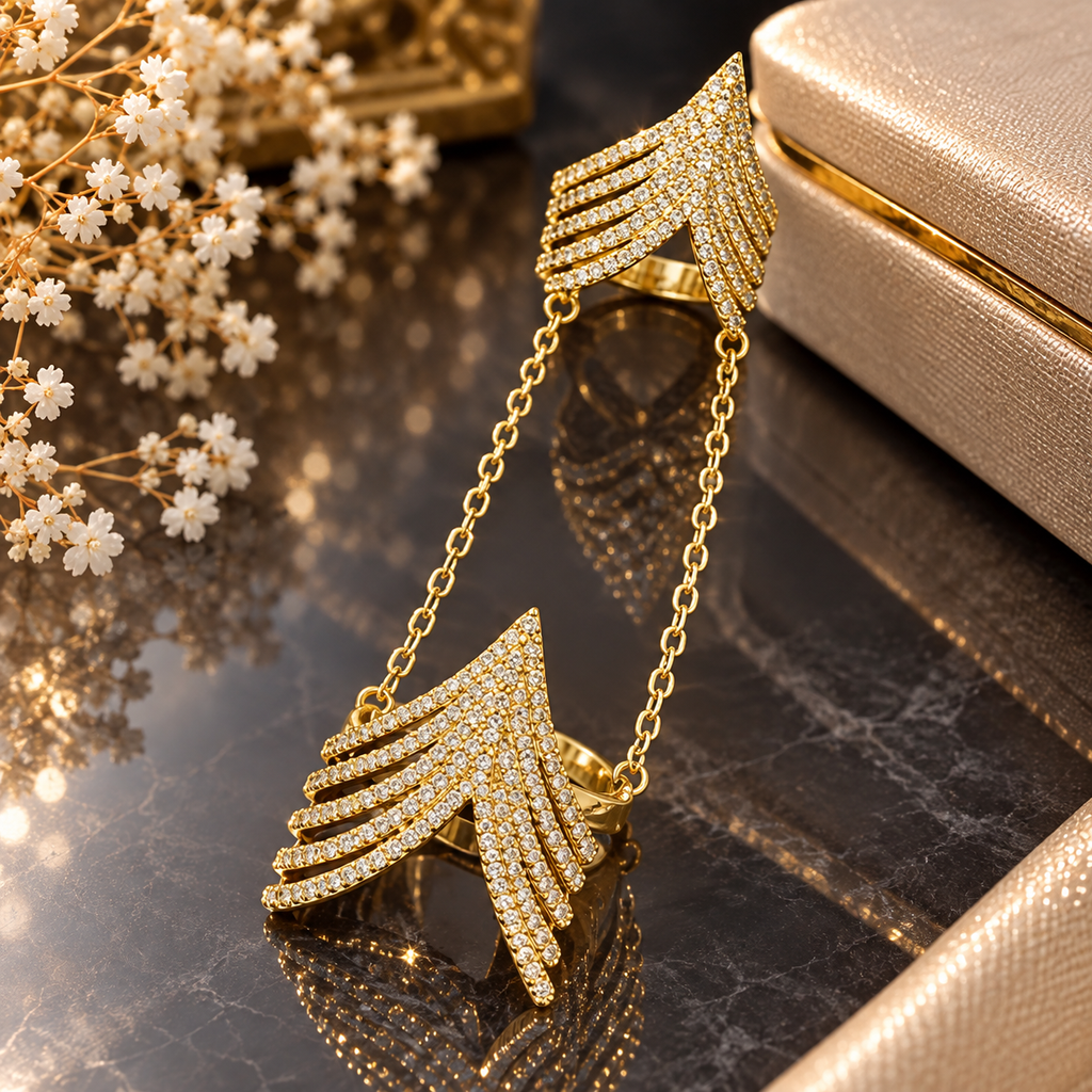 Gold-tone double finger ring with layered clear-accent chevron sections joined by two connecting chains.