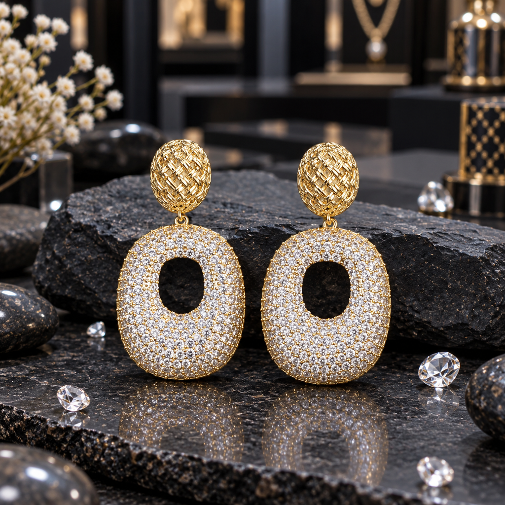 Gold-tone drop earrings with woven-look oval tops and broad clear-accent oval drops featuring open centres.