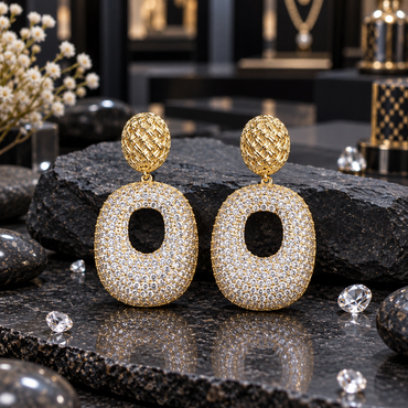 Gold-tone drop earrings with woven-look oval tops and broad clear-accent oval drops featuring open centres.