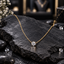 Gold-tone fine link necklace with a single round faceted clear-looking centre accent in a prong-style setting.