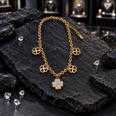 Gold-tone oval-link charm bracelet with four openwork clover charms and a larger central clover charm decorated with clear sparkling accents.