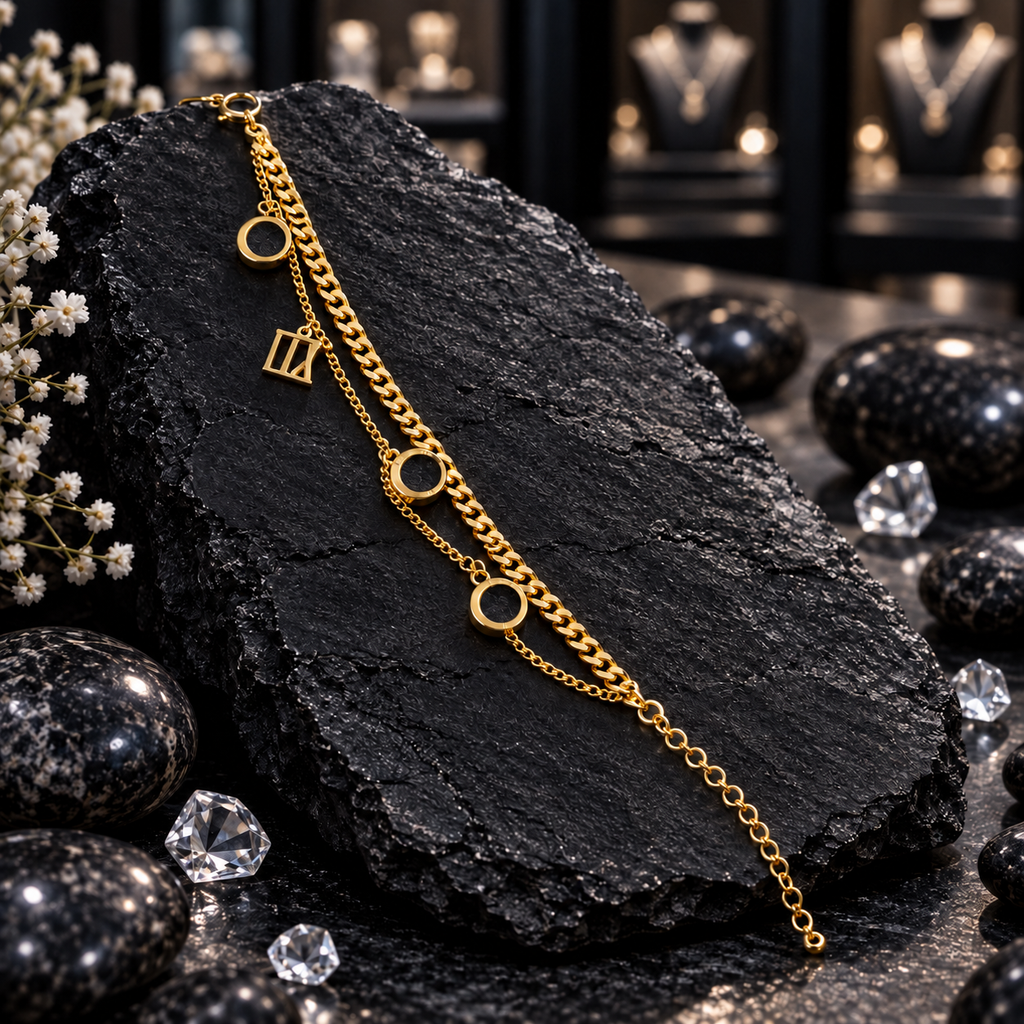Gold-tone double chain bracelet with a curb-style strand, a fine linked strand, three open circles, a rectangular openwork charm and round-link tail.