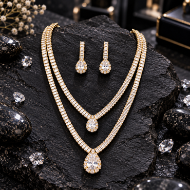Gold-tone double-layer rectangular-accent necklace with two graduated clear teardrop halo centres and matching drop earrings.