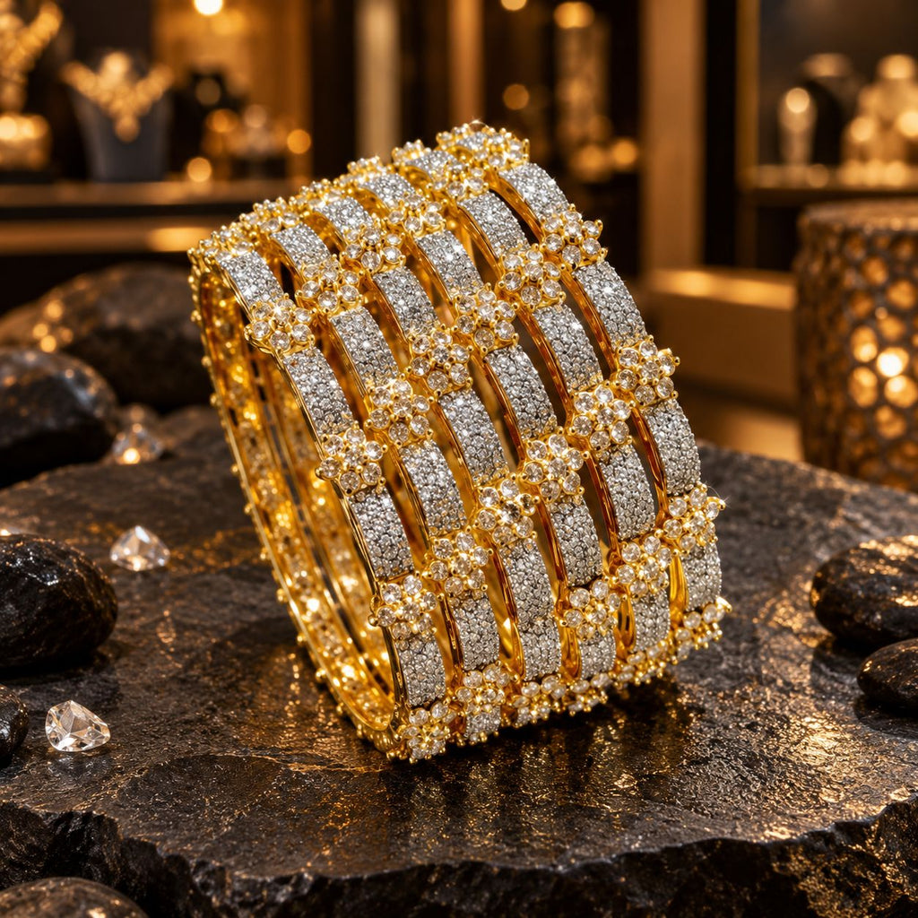 Set of six gold-tone bangles with clear accent-covered rectangular panels, round clear floral clusters and gold-tone borders, displayed together on dark slate.