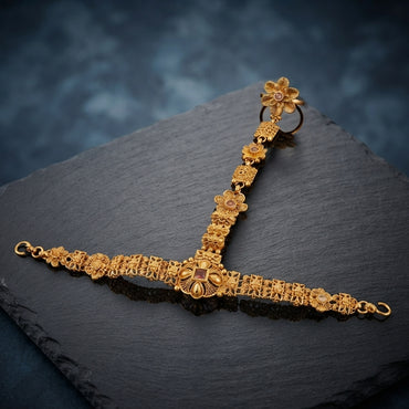 Gold-tone floral hathphool hand harness with an ornate wrist bracelet and linked finger ring, displayed on a dark surface.