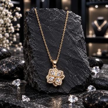 Gold-tone link chain necklace with a four-petal spinner locket, marquise-shaped clear accents, small clear halo borders and an openwork flower outline.