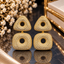 Gold-tone drop earrings with clear-accent rounded triangular tops, rounded square drops and circular open centres.
