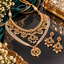 Gold-tone bridal necklace set with two necklaces, matching drop earrings, green and red accents, and ivory-colored pearl-like strands.