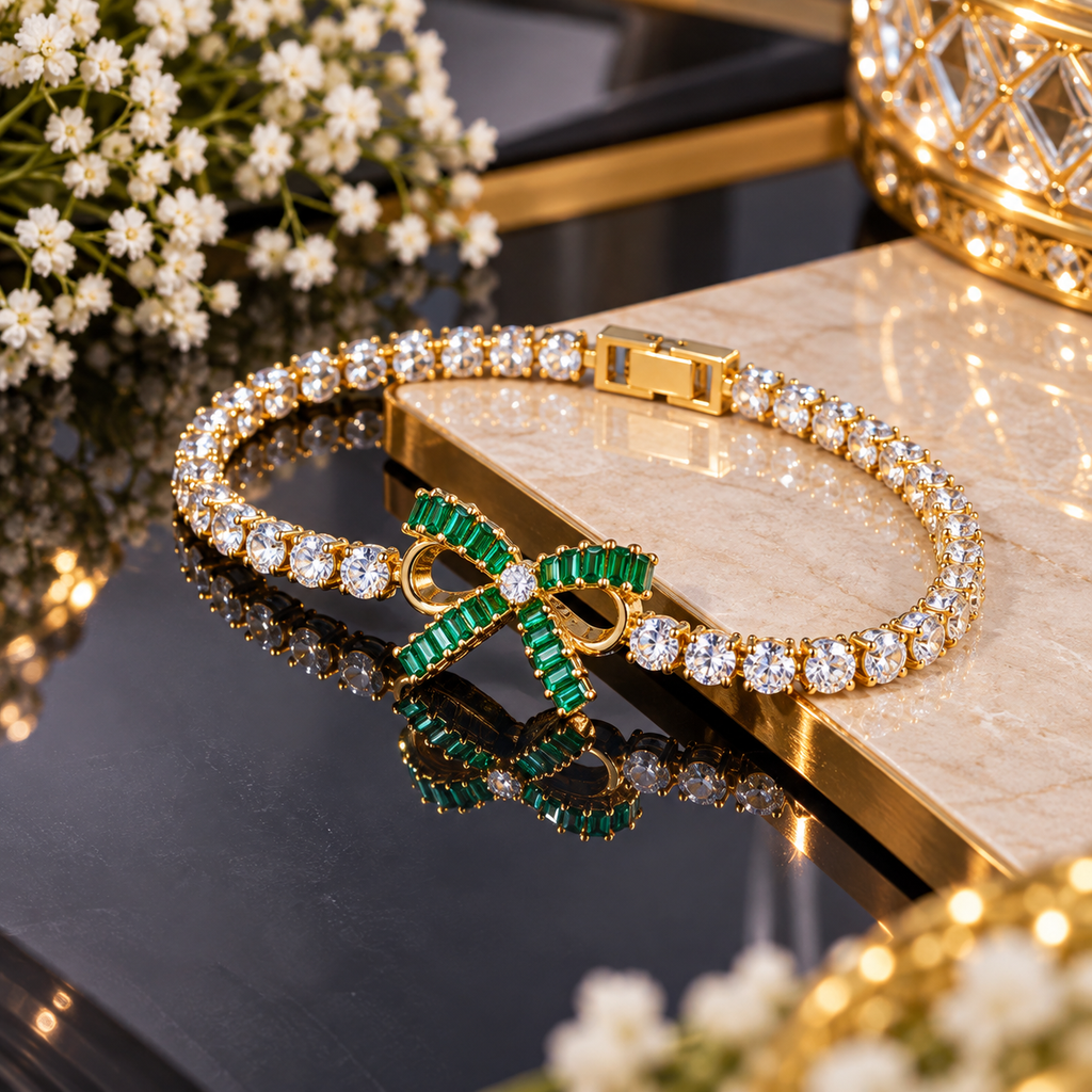 Gold-tone bracelet with round clear-accent links and a green rectangular-accent bow centre with open-loop detailing.