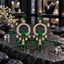 Pair of gold-tone circle chandelier earrings with green butterfly details, clear sparkling accents and graduated green teardrop drops.
