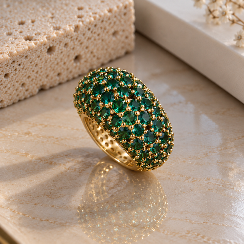 Gold-tone domed cluster ring with round green faceted accents and bead-like setting details.