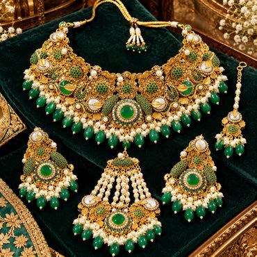 Gold-tone green floral necklace, earrings, bindia and pearl-look strand jhummer on green velvet, with round green centres and green drop fringe.