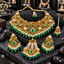 Gold-tone green floral necklace, matching earrings, bindia and jhummer on dark stone, with white pearl-look bead clusters and green oval drops.