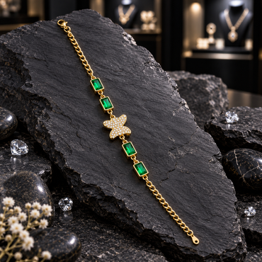 Gold-tone oval-link chain bracelet with a clear-accent butterfly centre, four framed green rectangular accents and a lobster-style clasp.