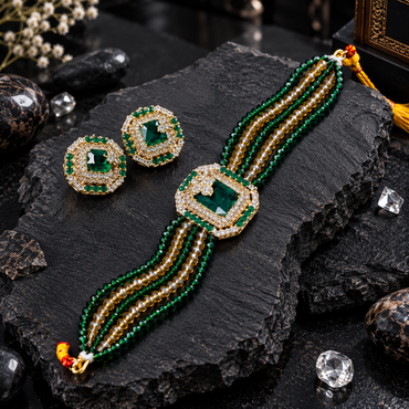 Gold-tone choker and matching square halo earrings with green centres, clear accent borders, green and champagne-coloured bead strands and yellow cord ties.