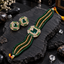 Gold-tone choker and matching square halo earrings with green centres, clear accent borders, green and champagne-coloured bead strands and yellow cord ties.