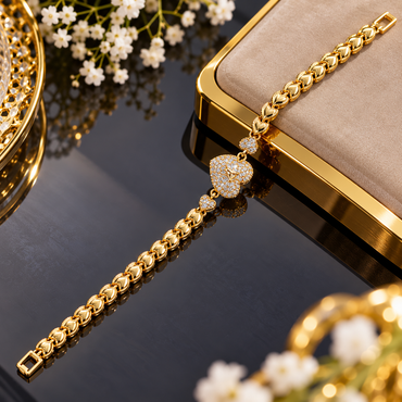 Gold-tone bracelet with repeating heart-shaped links, a large clear-accent heart centre and smaller clear-accent hearts on both sides.