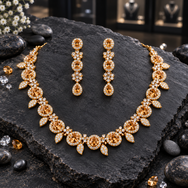 Gold-tone AD-style necklace with honey-gold-coloured oval halo accents and clear-looking leaf drops, alongside matching long teardrop-finish earrings.