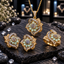 Gold-tone floral jewelry set with mint-green oval petals, clustered centres, sweeping clear-accent borders, pendant with chain, matching earrings and ring.