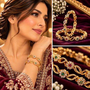 Gold-Tone Multi-Color CZ Floral Infinity Twist Slim Bangle Pair worn on model wrist in maroon embroidered bridal outfit with collage showing close-up on burgundy velvet tray and macro detail of ruby-red and emerald-green CZ floral rosettes on gold infinity twist bangle