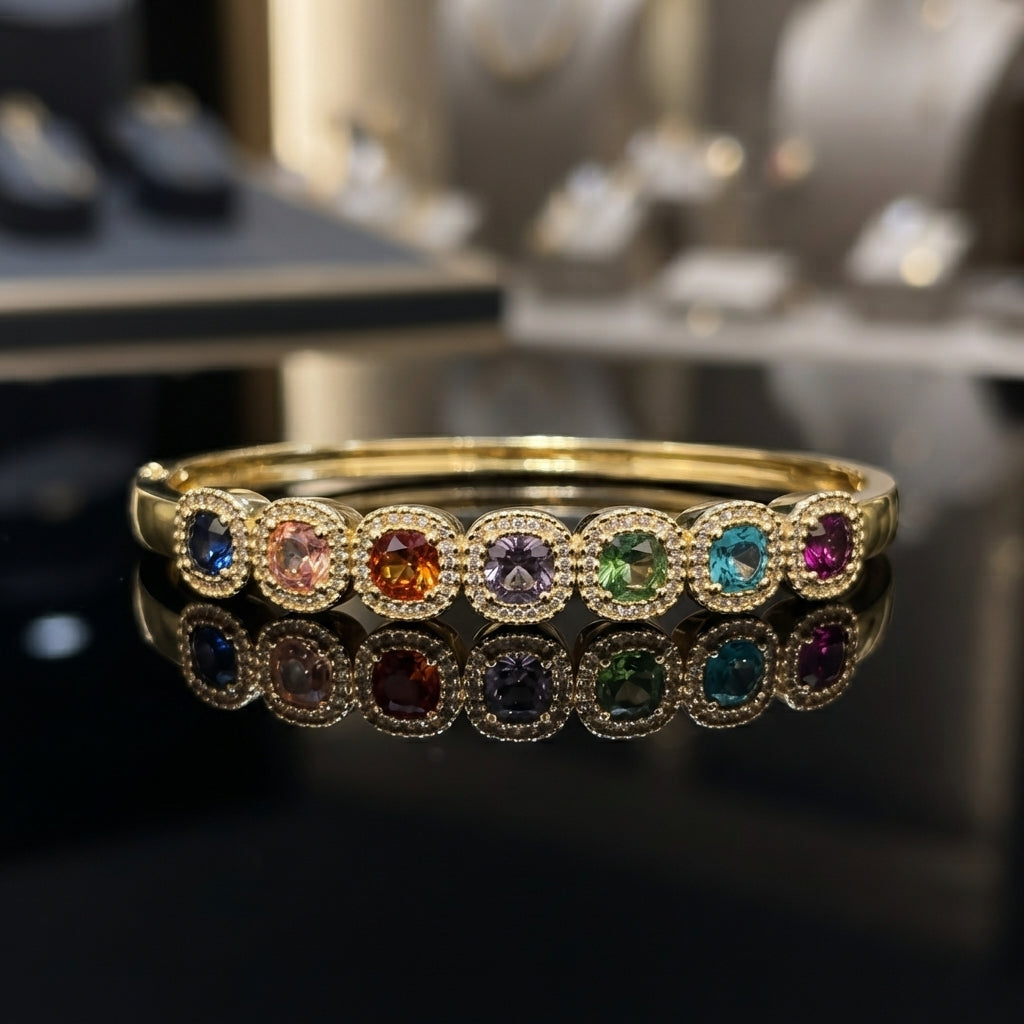 Gold-tone bangle with multicolor halo-accent motifs, shown on a wrist.