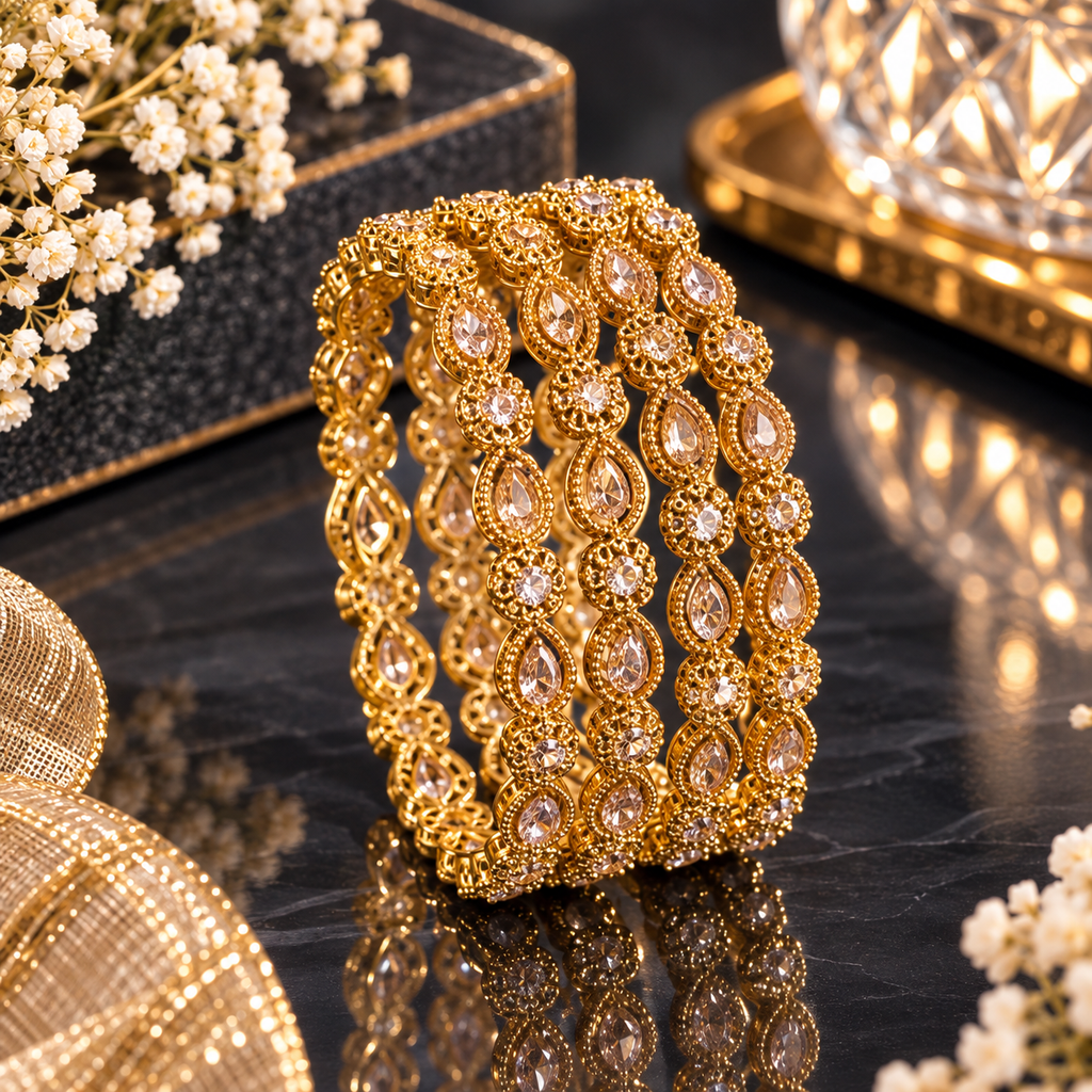 Ornate gold-tone bangles featuring clear teardrop-shaped and round accents.