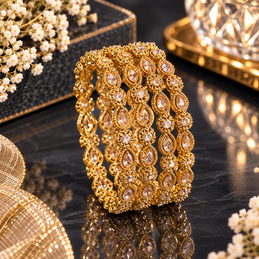 Ornate gold-tone bangles featuring clear teardrop-shaped and round accents.