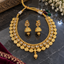 Gold-tone necklace and jhumka-style earrings with clear oval accents, round embossed necklace details, and textured hanging drops.