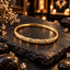 Gold-tone bangle with oval panels of small clear accents, raised gold-tone divider ridges and a smooth rear band.