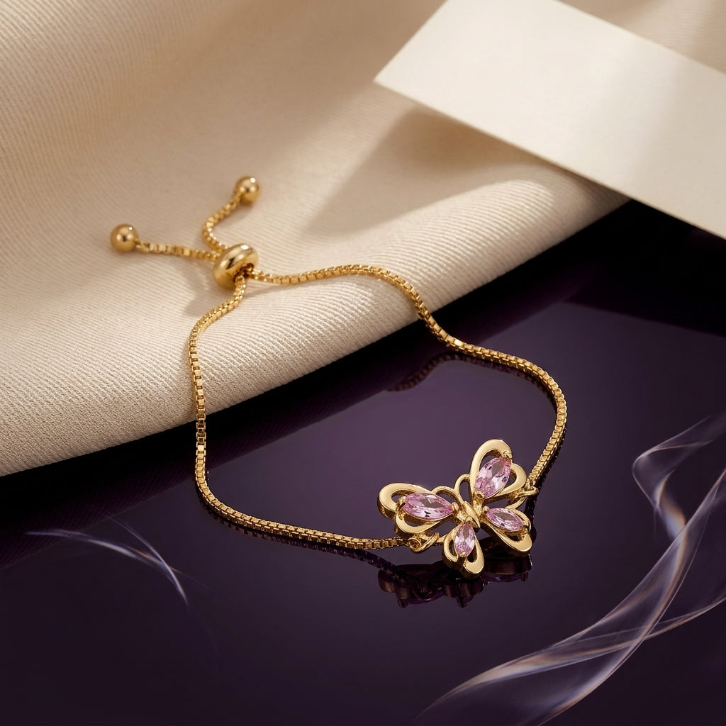 Gold-Tone Pink CZ Butterfly Adjustable Bracelet product shot on dark surface with cream fabric