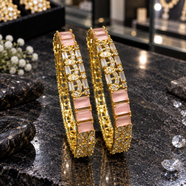 Pair of gold-tone bangles with pale pink rectangular panels, clear elongated rectangular accents, marquise-shaped details and small round accent rows.