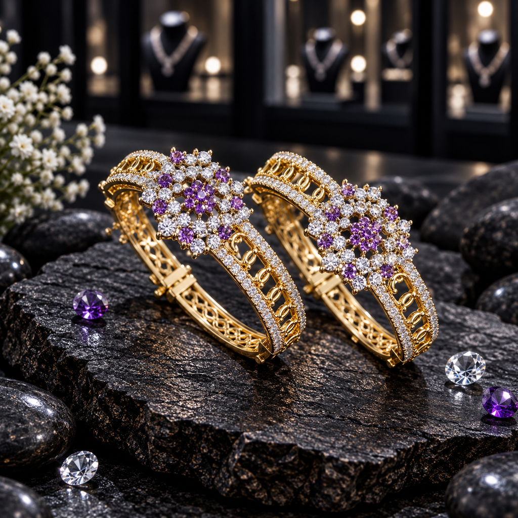 Pair of gold-tone openwork bangles with purple and clear floral clusters and clear accent borders, displayed upright on dark slate.