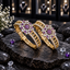 Pair of gold-tone openwork bangles with purple and clear floral clusters and clear accent borders, displayed upright on dark slate.