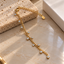 Gold-tone curb-style chain bracelet with mixed-size dangling round clear accents, circular settings, a lobster-style clasp and extension chain.