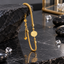 Gold-tone textured chain bracelet with a patterned round medallion, rounded bead details, a lobster-style clasp and an extension chain ending in a heart-shaped charm.