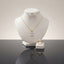 Gold-tone set displayed with a clear-stone pendant necklace, stud earrings, and matching ring.