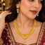 Model wearing a gold-tone spiral disc necklace with a pearl-look centre drop and matching jhumka-style earrings with pearl-look drops.