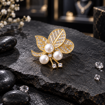 Gold-tone three-leaf ornament with clear-accent vein panels, three cream-white pearl-look beads and slender clear-tipped stems.