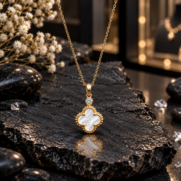 Gold-tone link chain necklace with a white iridescent-look clover pendant, beaded-looking border and round clear accent above the clover.