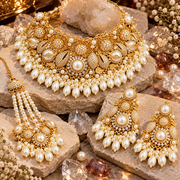 Gold-tone white pearl-look floral necklace, matching earrings and multi-strand jhummer with round centres, beaded teardrop motifs and pear-shaped drop fringe.