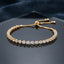 Gold Trillion CZ Tennis Adjustable Bracelet — 22K gold-tone full tennis bracelet with continuous trillion triangle cut white CZ chevron band in 3-prong gold settings, graduating stone size, and adjustable sliding gold ball closure, on dark hexagonal mirror tray with navy velvet backdrop