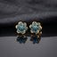 Gold Turquoise Pavé Flower Stud Earrings on dark grey mirror surface with dark grey fabric drape backdrop